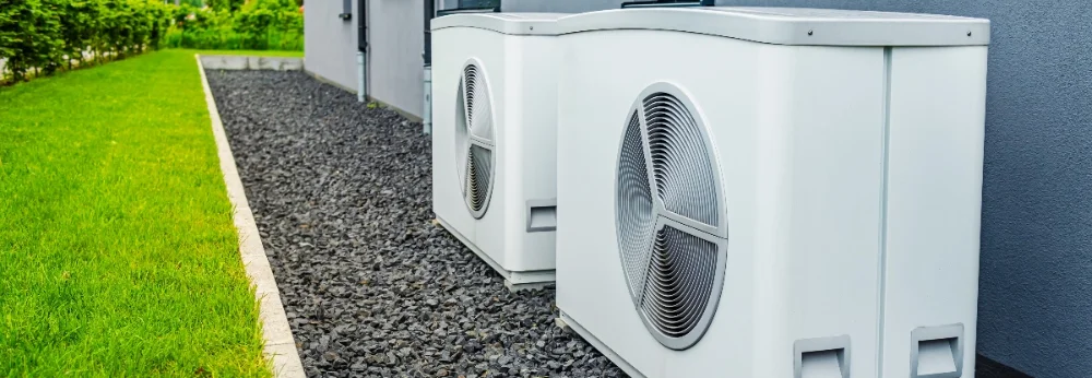 Zwei weiße Wärmepumpen an Hauswand